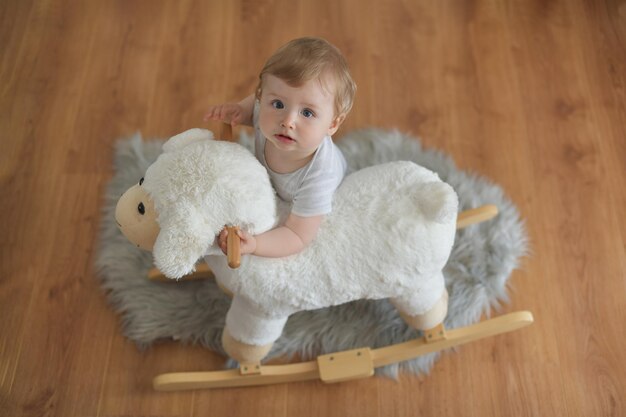 Bambino di un anno con un giocattolo di pecora soffice