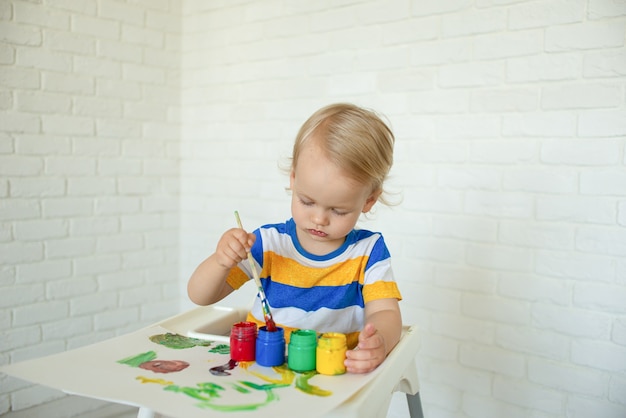 bambino disegna con le vernici, giocando a casa. bambino con giocattoli educativi per la creatività