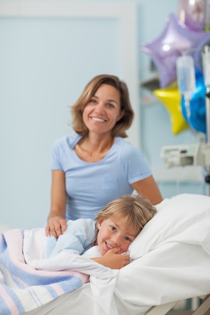 Bambino disteso su un letto accanto a sua madre