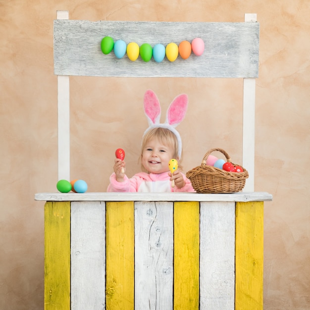 Bambino divertente che indossa il coniglietto di Pasqua. Bambino che si diverte a casa.