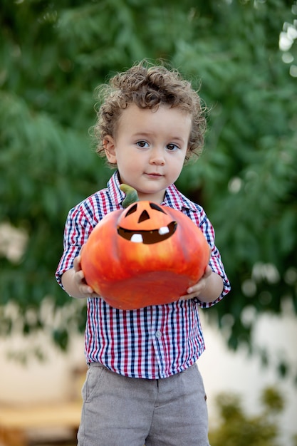 Bambino divertente che tiene una grande zucca