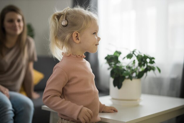 Bambino divertente con impianto cocleare Hear aid and medicine tecnologia innovativa e concetto di diversità