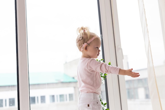 Bambino divertente con impianto cocleare seduto a casa e mangiare Apparecchio acustico e medicina innovando il concetto di tecnologia