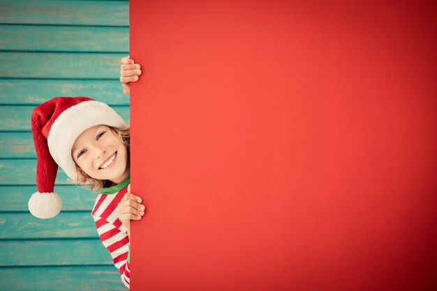 bambino divertente con striscione in cartone bambino bianco che gioca a casa vacanze di natale