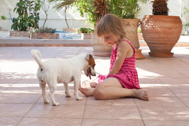 Bambino e cane che giocano insieme all'aperto