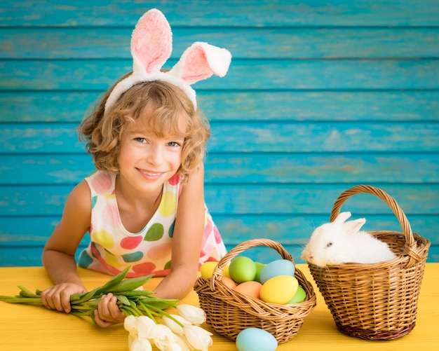 Bambino e coniglietto di Pasqua. Bambino che gioca con coniglio e uova