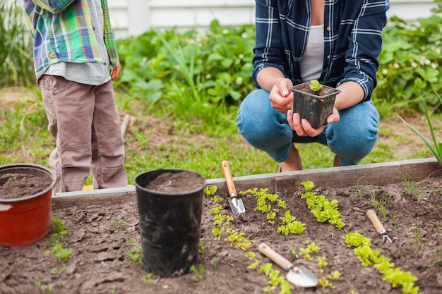 Bambino e madre che fanno giardinaggio nell'orto nel cortile