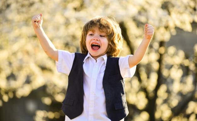 Bambino eccitato Ragazzo adorabile giardino primaverile Giornata internazionale dei bambini Infanzia felice Bambino sano Cura dei bambini Festeggia le vacanze estive Ragazzo natura sfondo Sviluppo del bambino Felicità