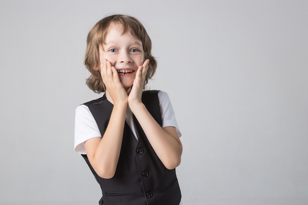 Bambino emotivamente in posa sulla fotocamera in Studio su sfondo bianco