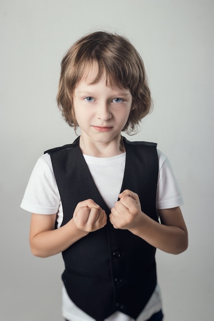 Bambino emotivamente in posa sulla fotocamera in Studio su sfondo bianco