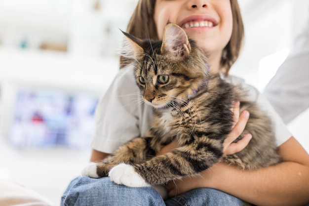 Bambino felice a casa giocando con gattino gatto