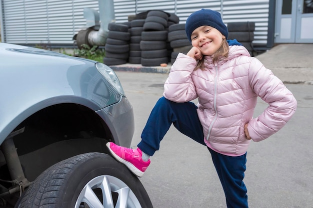 Bambino felice al servizio auto in posa sulla macchina fotografica Servizio di riparazione