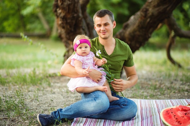 Bambino felice bambina tra le braccia di suo padre al picnic