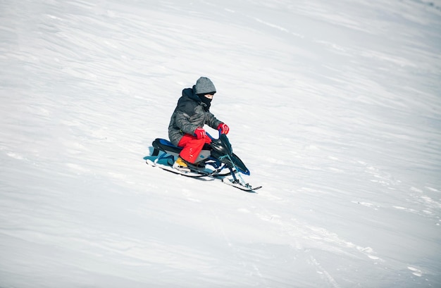 Bambino felice che gioca a una passeggiata invernale in natura Bambino che si gode un giro in slitta in slitta sulla neve