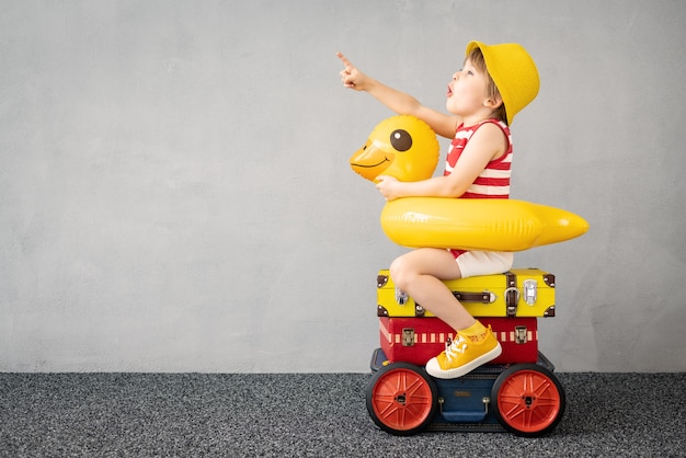 Bambino felice che gioca all'aperto. Bambino sorridente che sogna di vacanze estive e viaggi. Immaginazione e concetto di libertà