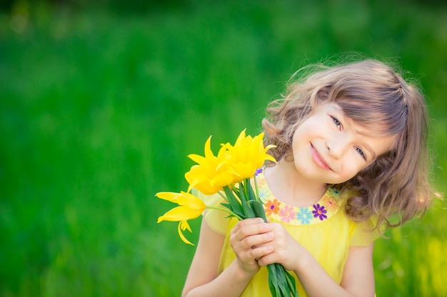 Bambino felice che gioca all'aperto nel parco di primavera