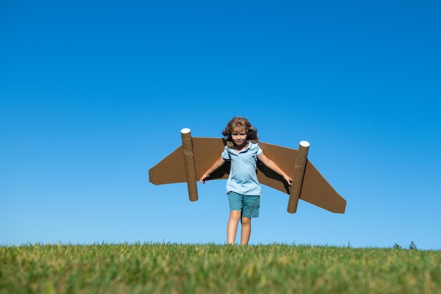 Bambino felice che gioca con il pilota giocattolo jetpack kid divertendosi all'aperto successo bambino innovazione e leade