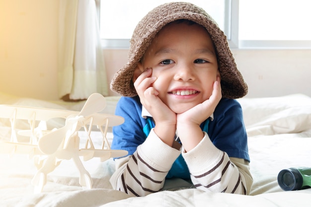 Bambino felice che gioca con l&#39;aeroplano del giocattolo, piccolo ragazzo asiatico godere di viaggi, concetto di viaggio e avventura