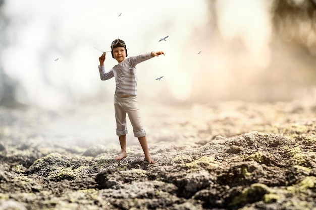 Bambino felice che gioca con l'aeroplano di carta Tecnica mista