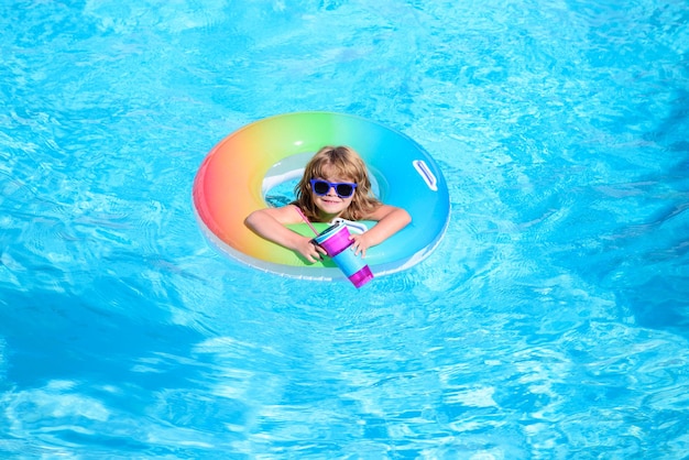 Bambino felice che gioca con l'anello di nuotata colorato in piscina il giorno d'estate giocattoli d'acqua per bambini p