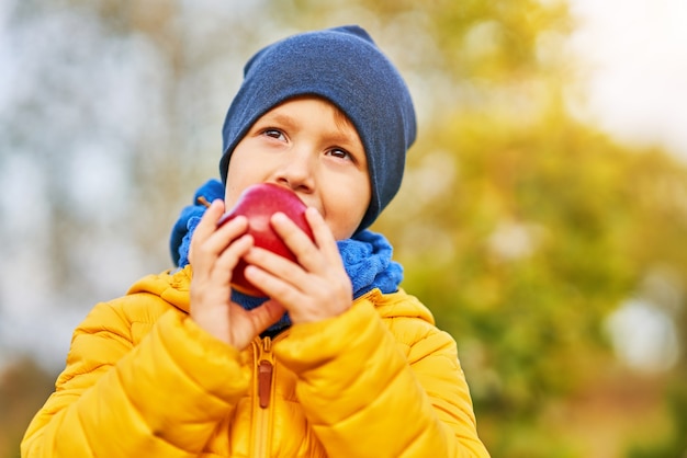 bambino felice che gioca fuori in autunno