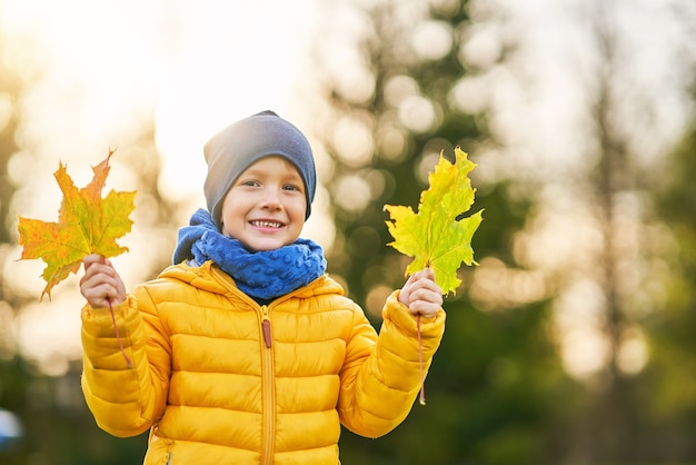 bambino felice che gioca fuori in autunno