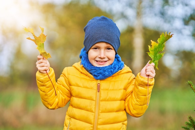 bambino felice che gioca fuori in autunno