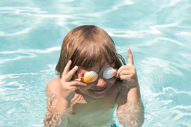 Bambino felice che gioca in mare Bambino che si diverte all'aperto Vacanze estive e concetto di stile di vita sano Occhi coperti con conchiglie