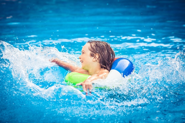 Bambino felice che gioca in piscina