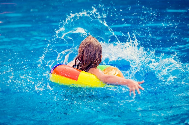 Bambino felice che gioca in piscina