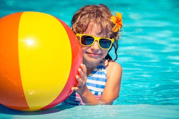 Bambino felice che gioca in piscina