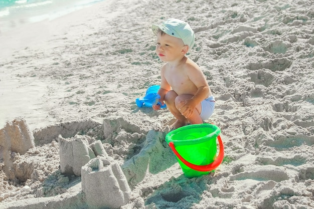 Bambino felice che gioca in riva al mare all'aperto