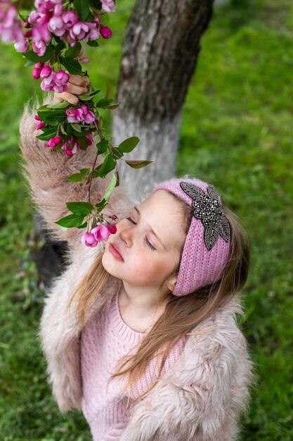 Bambino felice che gioca nel giardino che si arrampica sull'albero