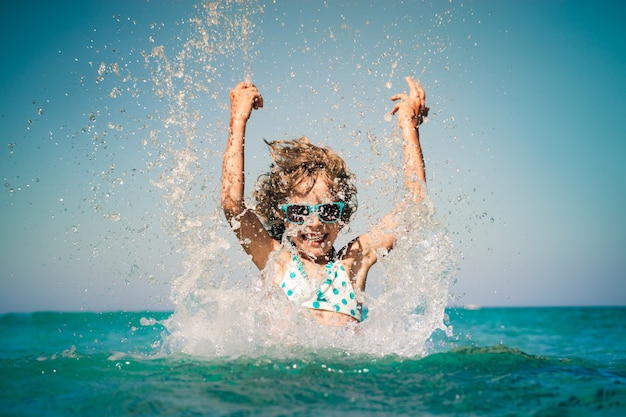 bambino felice che gioca nel mare