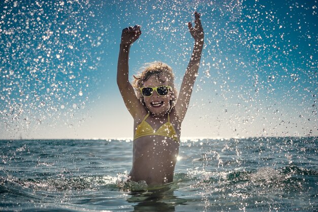 bambino felice che gioca nel mare