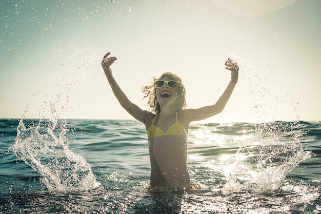 bambino felice che gioca nel mare