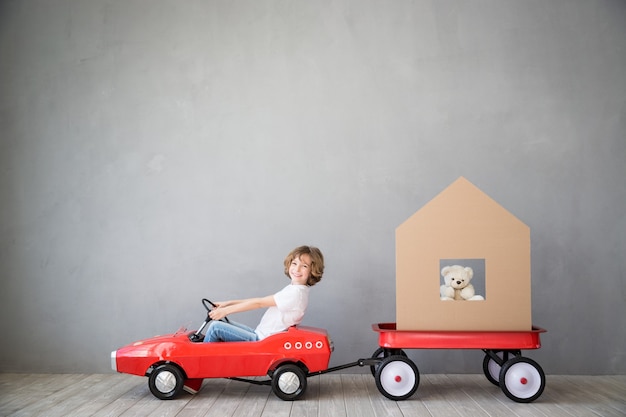 bambino felice che gioca nella nuova casa bambino che si diverte al trasloco al coperto e consegna espressa