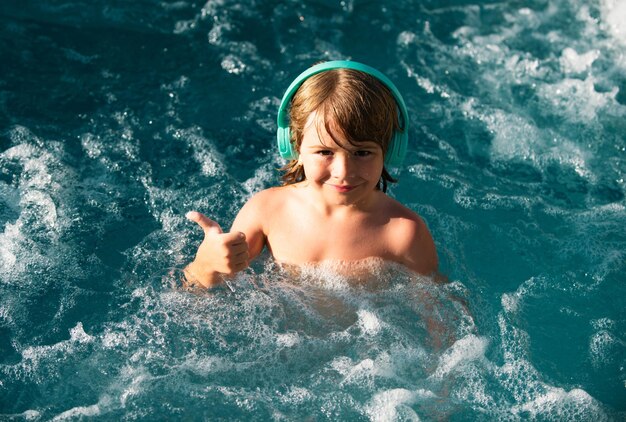 Bambino felice che gioca nella piscina all'aperto nelle calde giornate estive i bambini imparano a nuotare bambino in acqua bambino