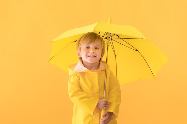 Bambino felice che indossa un impermeabile