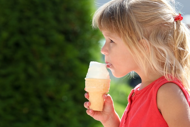 Bambino felice che mangia il gelato sulla natura del parco