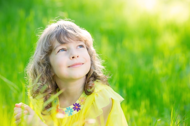 bambino felice che soffia fiore di tarassaco all'aperto ragazza che si diverte nel parco di primavera spring