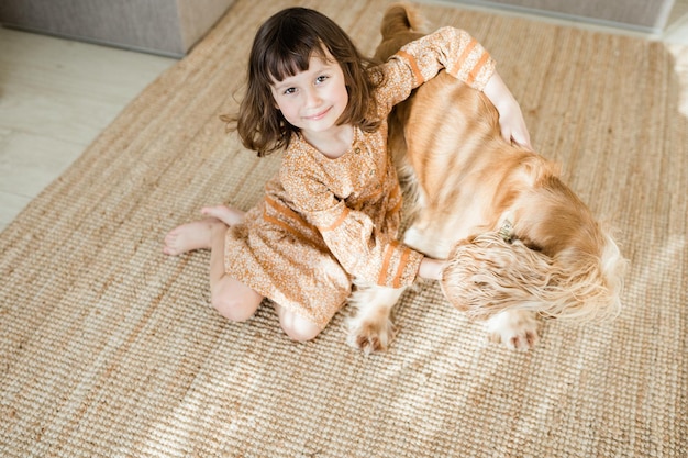 Bambino felice con animale domestico nel soggiorno di casa