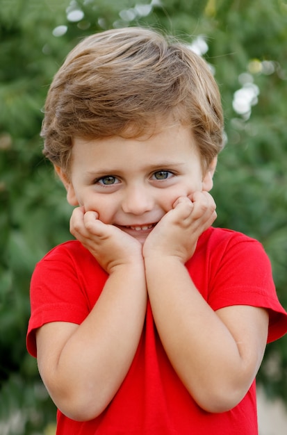 Bambino felice con la maglietta rossa nel giardino