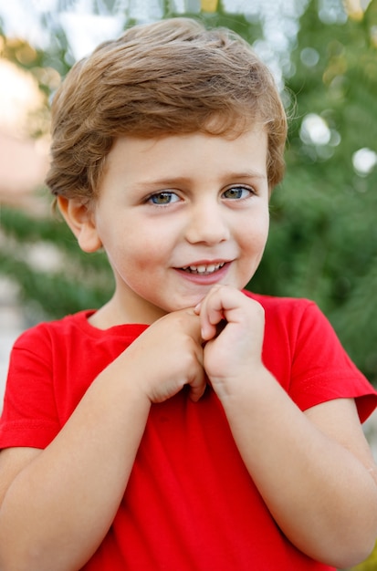 Bambino felice con la maglietta rossa nel giardino