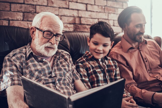 Bambino felice con padre e nonno in barbiere