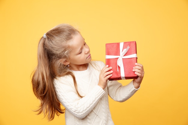 Bambino felice con regalo isolato su sfondo giallo