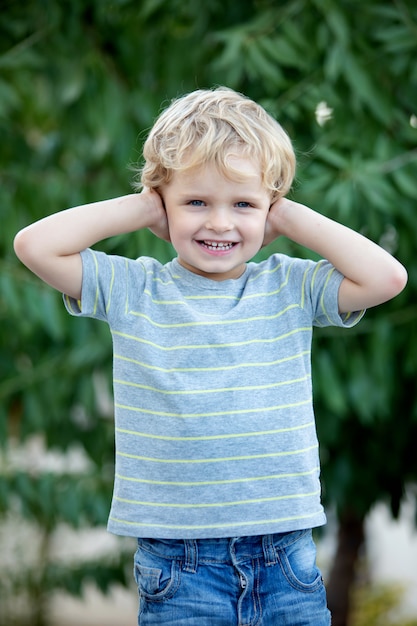 Bambino felice con t-shirt blu in giardino