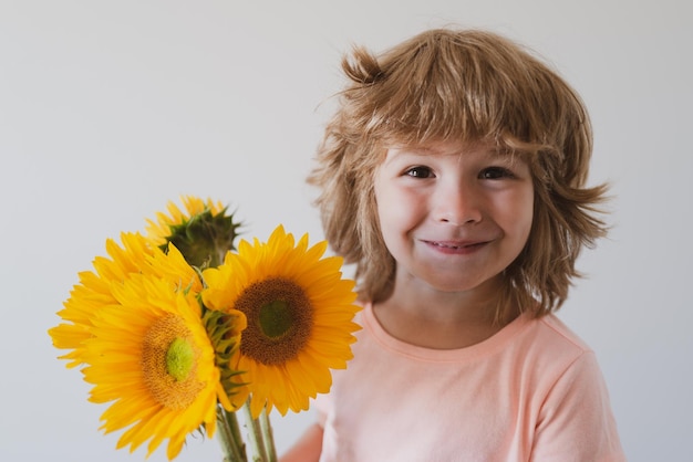 Bambino felice del figlio con il mazzo di fiori. Concetto di vacanza in famiglia di primavera. Festa della Donna.