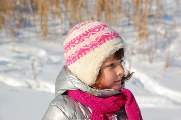 Bambino felice divertirsi nella foresta invernale. Bambina all'aperto