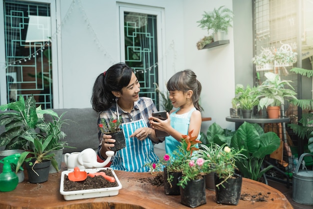 Bambino felice e madre che fanno il giardinaggio a casa